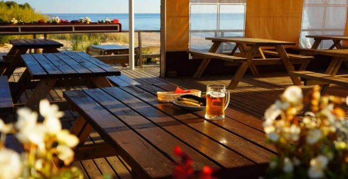 Maistas ir alaus bokalas ant stalo kavinukėje prie pat jūros Latvijoje